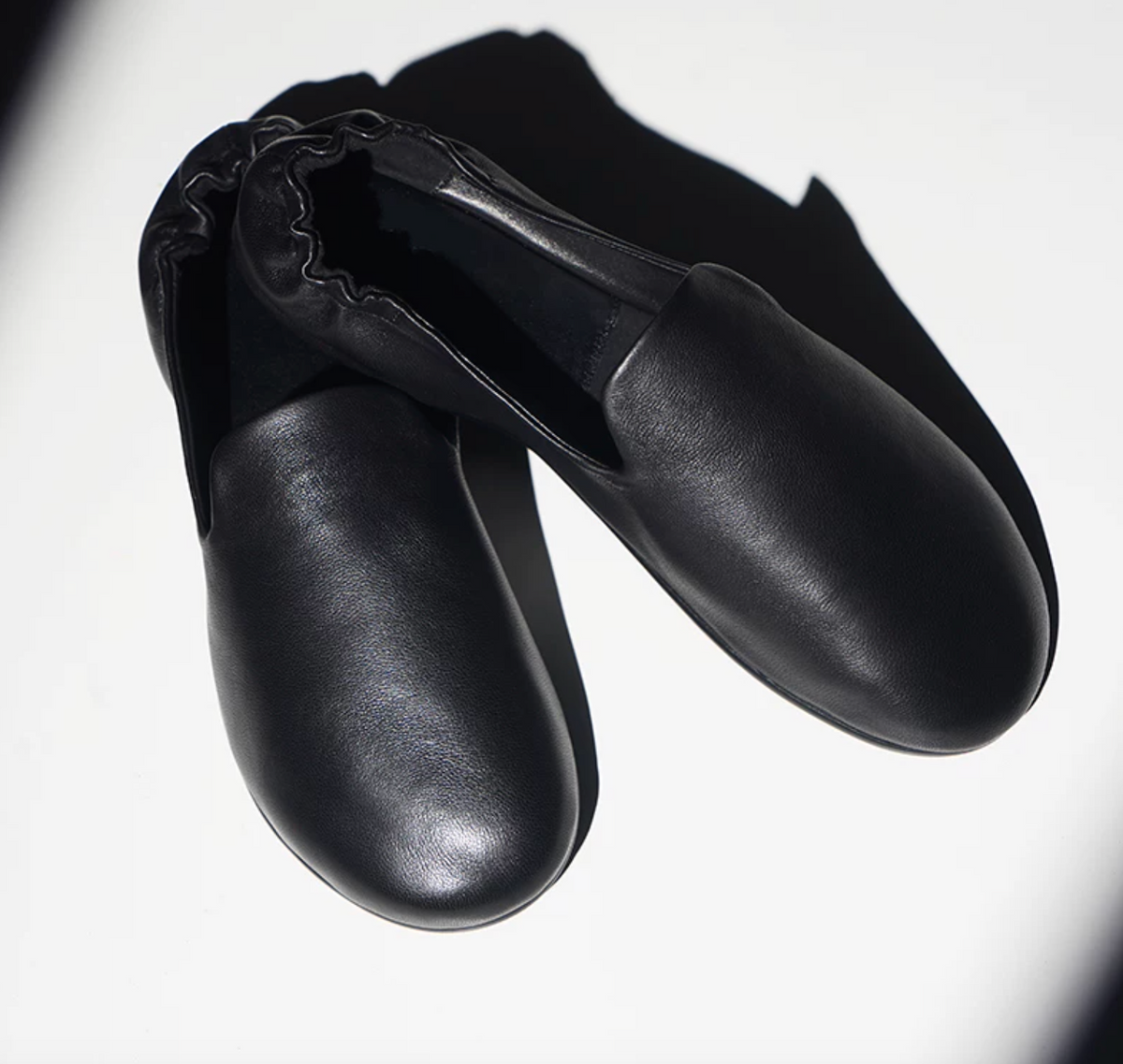 Front view of Black lambskin slipper loafers with soft round toes and clean vamps