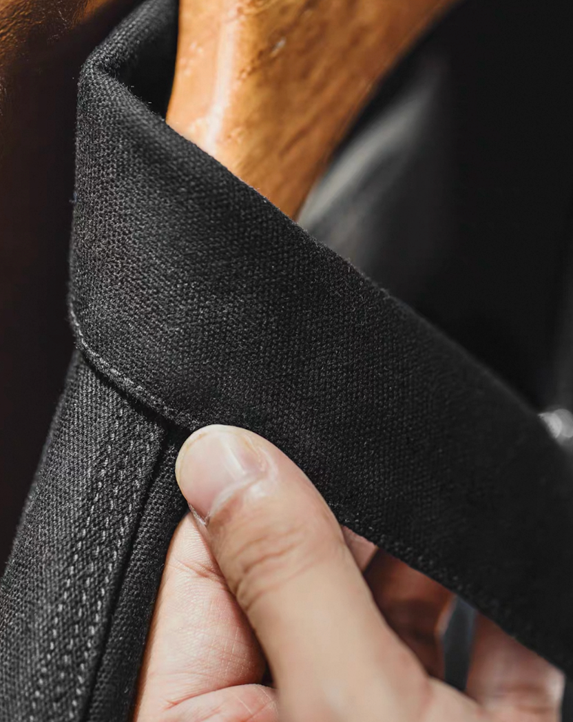 Close-up of collar detail on black cotton workwear jacket