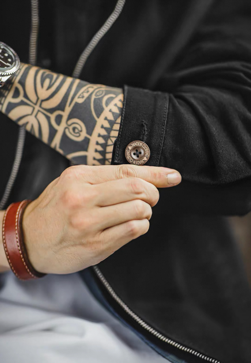 Adjustable cuff button detail on black cotton workwear jacket