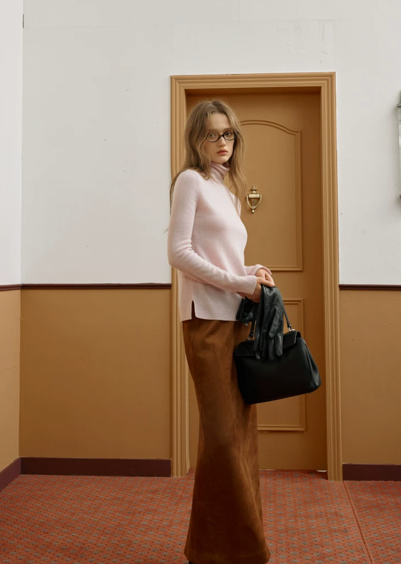 Full-length view of a Blush Pink cashmere turtleneck showing the side slit at the hem