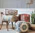 Bohemian patterned square floor pouf cushion in multiple colors displayed together in a living room