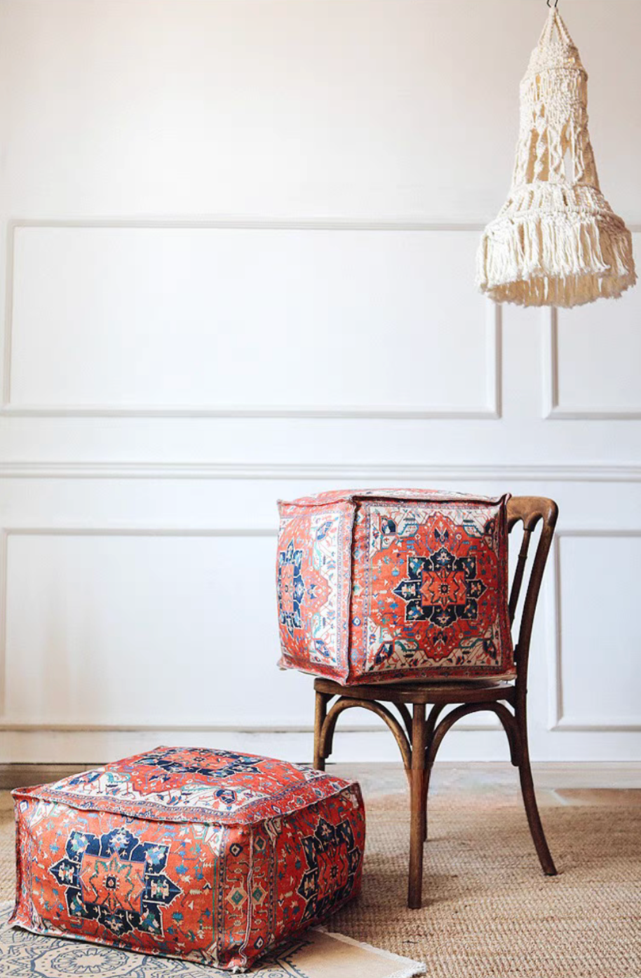 Persian Red bohemian patterned square floor pouf cushion displayed on and beside a wooden chair