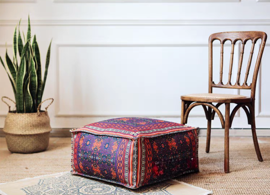 Vintage Red bohemian patterned square floor pouf cushion displayed on the floor beside a wooden chair