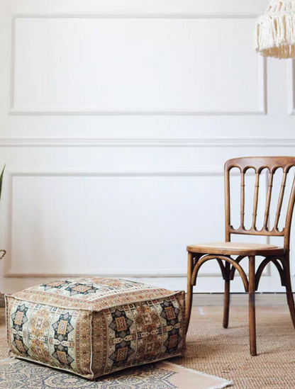 Vintage Red bohemian patterned square floor pouf cushion displayed on the floor beside a wooden chair