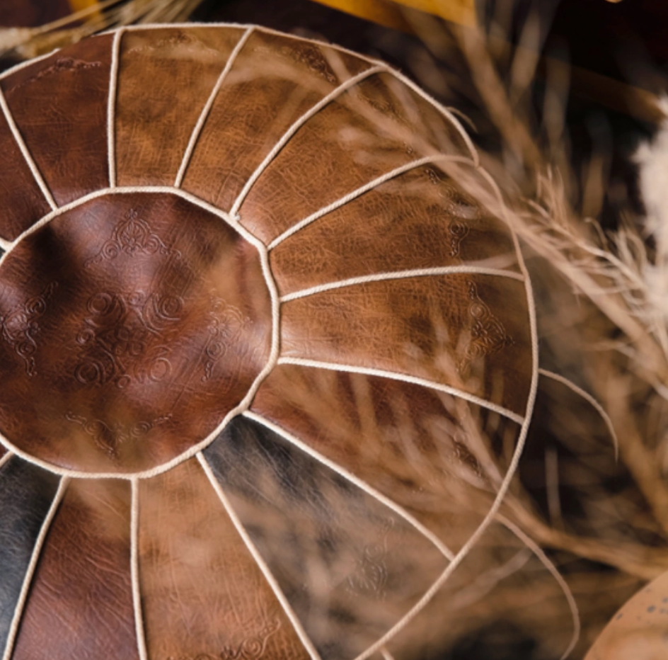 Close-up detail of camel faux leather pouf showing stitching and texture