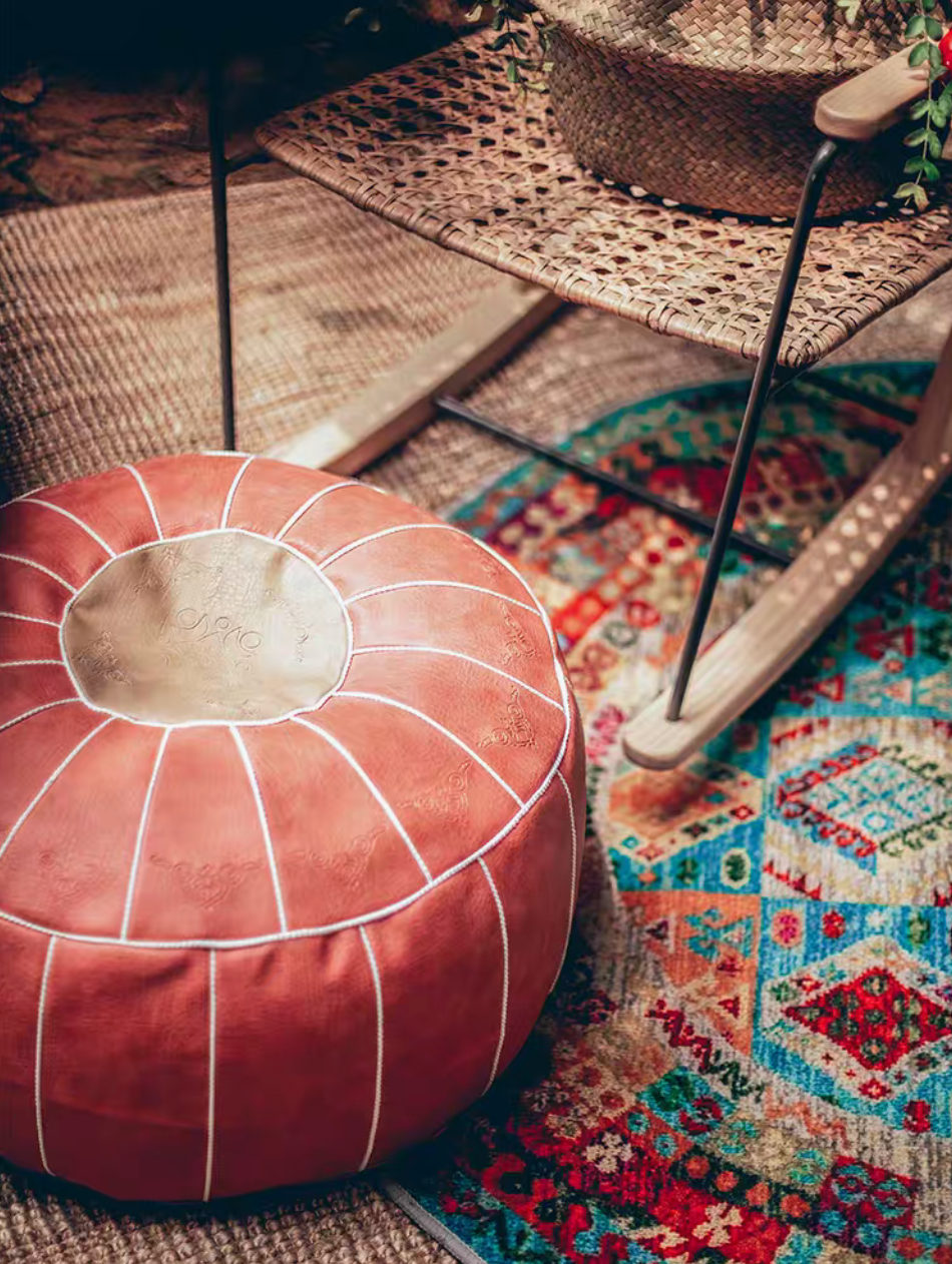 Pink faux leather pouf close-up showing stitched panels and textured surface