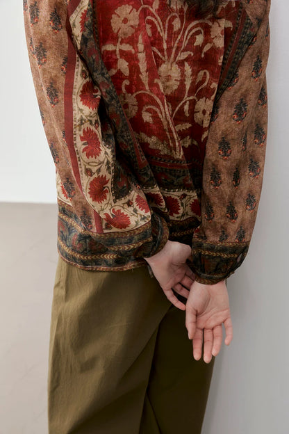 Back detail of rust floral print blouse showing raglan sleeve and cuff