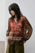 Close-up of rust floral print blouse showing V-neck and button placket