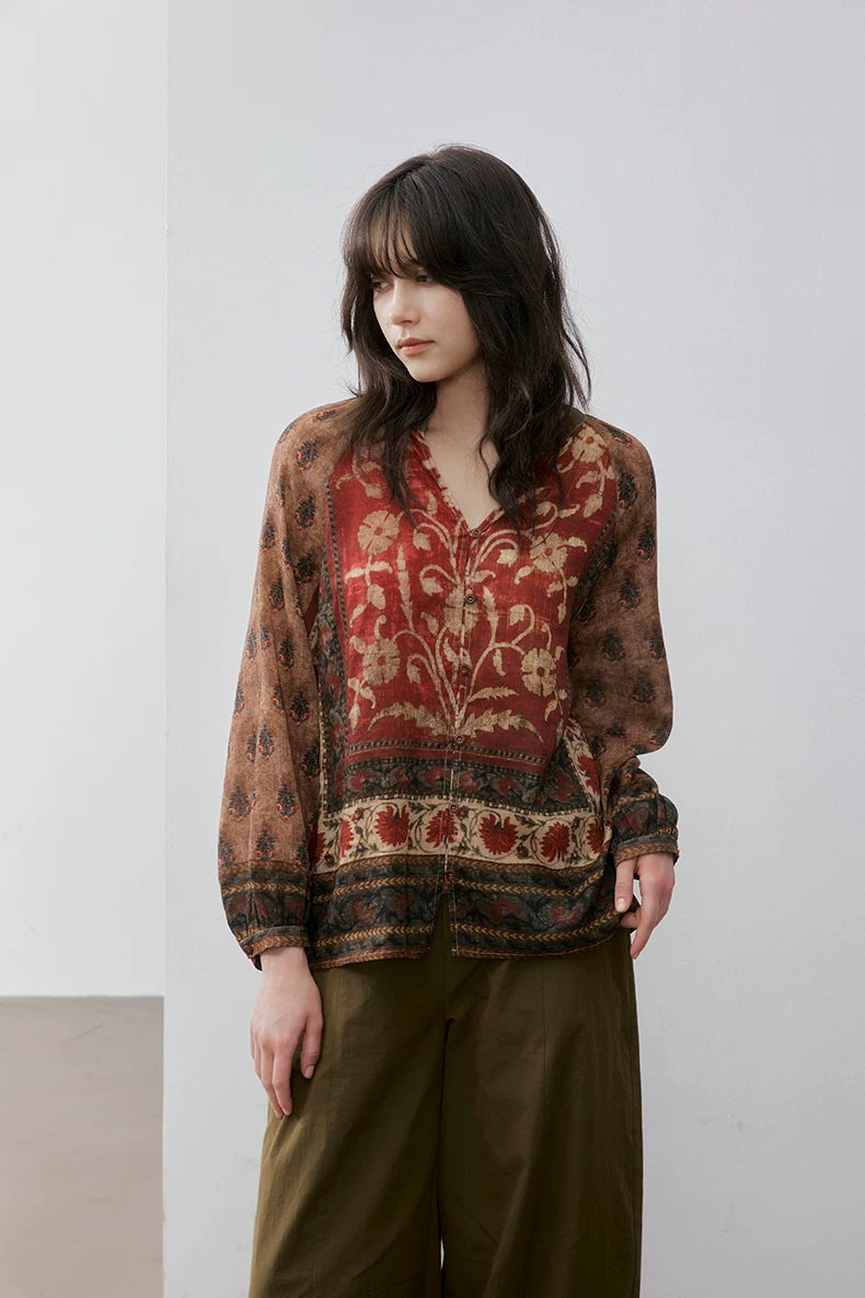 Woman wearing rust floral print blouse with olive green wide-leg pants