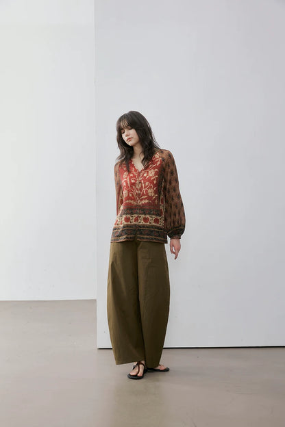 Full outfit view of rust floral print blouse with olive wide-leg trousers