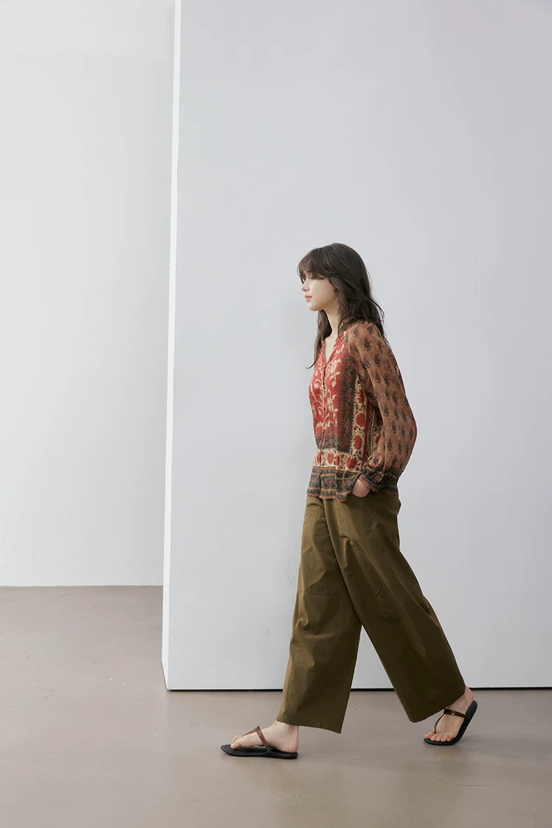 Side view of woman walking in rust floral print blouse