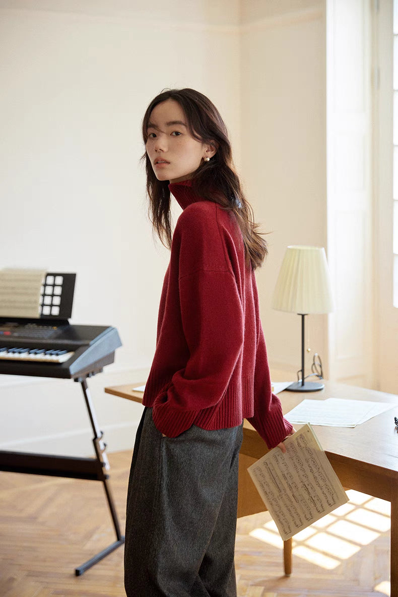 Side profile of model wearing red Bordeaux Wool-Cashmere Turtleneck Sweater holding paper showing dropped shoulders and clean silhouette