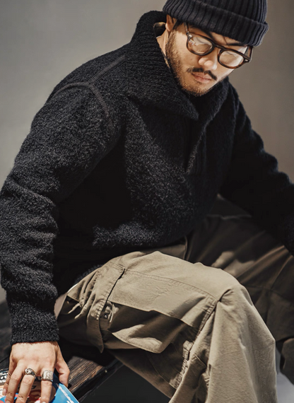 Model sitting in Black Bouclé Polo Sweater paired with khaki pants