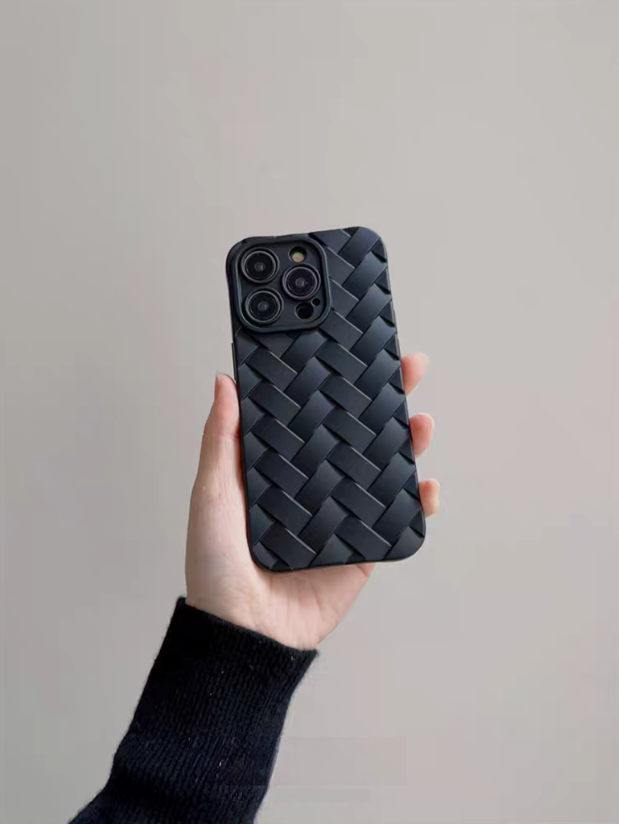 Black braided silicone phone case held in hand showing textured woven design and raised camera edges