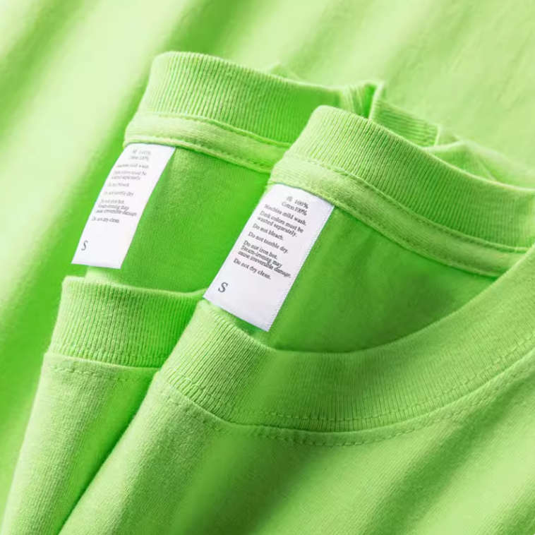 Close-up of green cotton T-shirt collar and inner label showing stitching and neckline