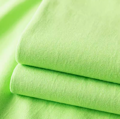 Folded green cotton T-shirt fabric close-up highlighting soft texture and material