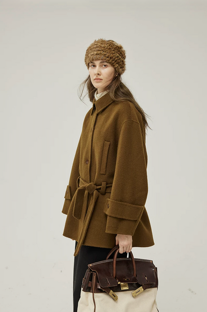 Side view of a Brown belted wool coat showing the welt pocket, wide cuff, and boxy cut