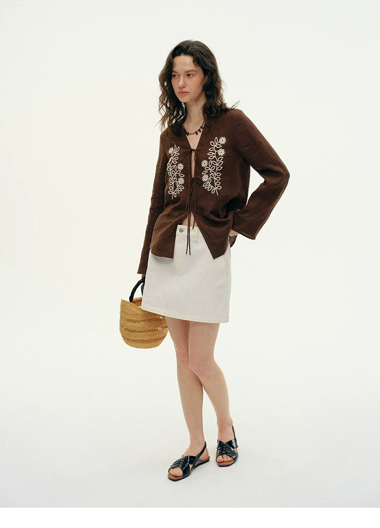 Full outfit view of brown embroidered hemp cardigan styled with woven bag and sandals