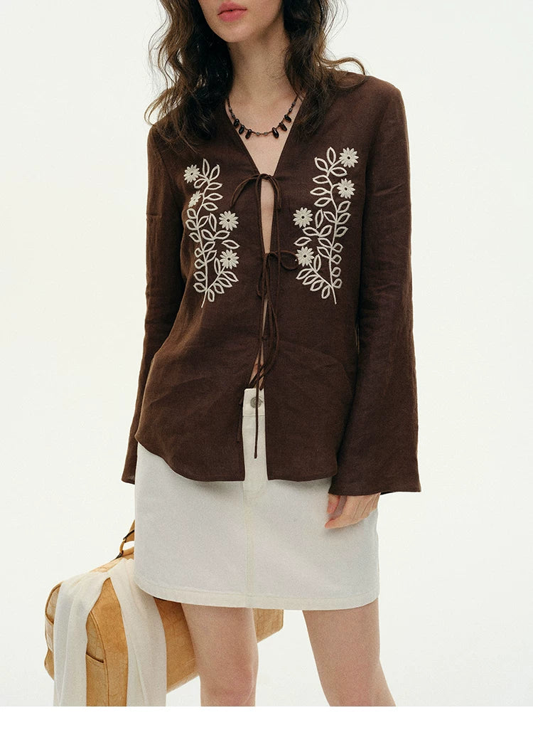 Close-up of brown hemp cardigan V-neck and floral vine embroidery detail