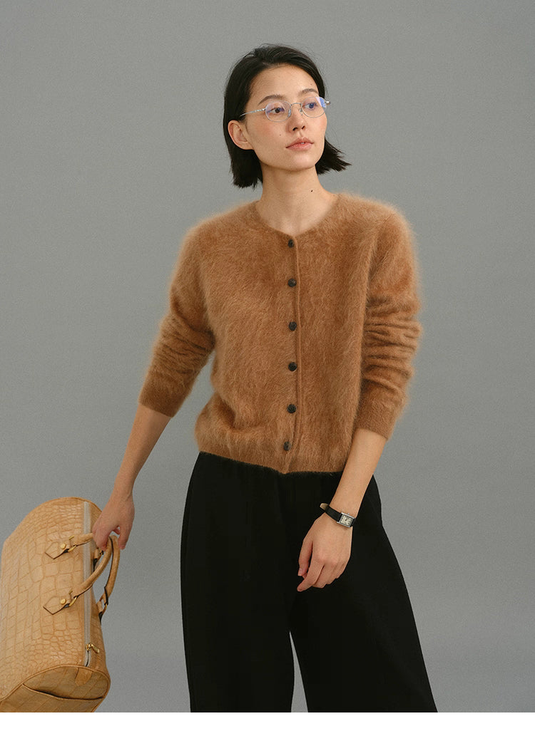 Woman wearing caramel brushed cashmere cardigan, full front view with black trousers.