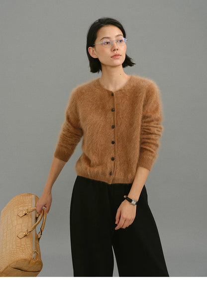 Woman wearing caramel brushed cashmere cardigan, full front view with black trousers.