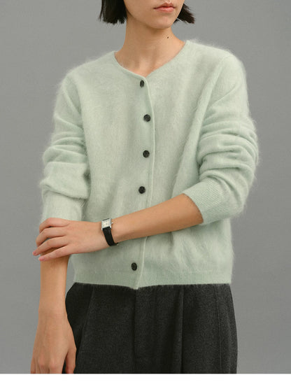 Close-up of mint green brushed cashmere cardigan showing lightweight fuzzy texture.
