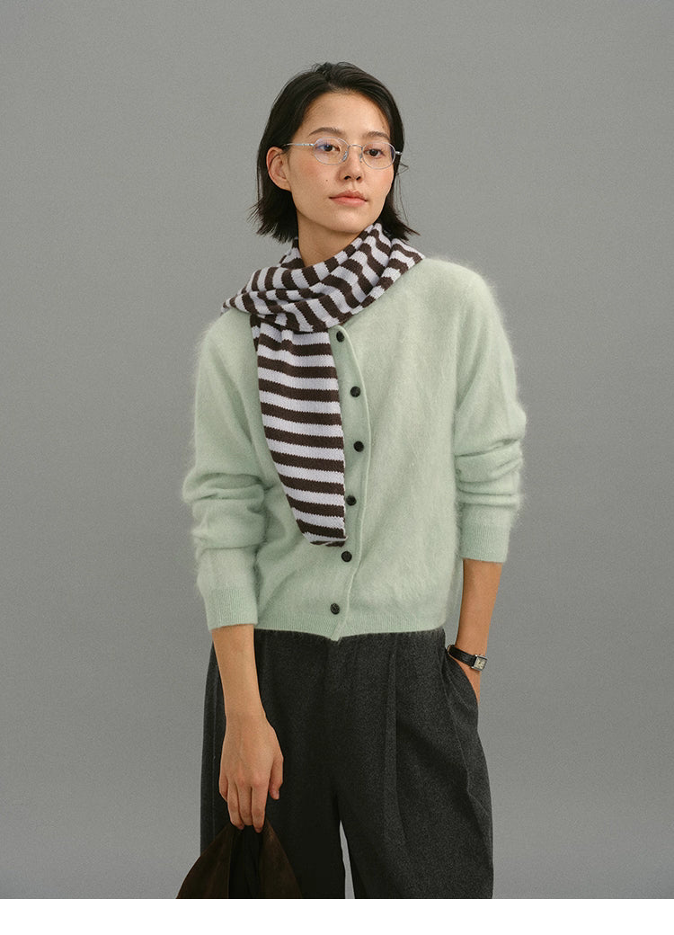 Mint green brushed cashmere cardigan styled with striped scarf and gray trousers.