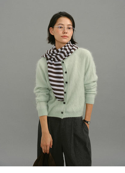 Mint green brushed cashmere cardigan styled with striped scarf and gray trousers.