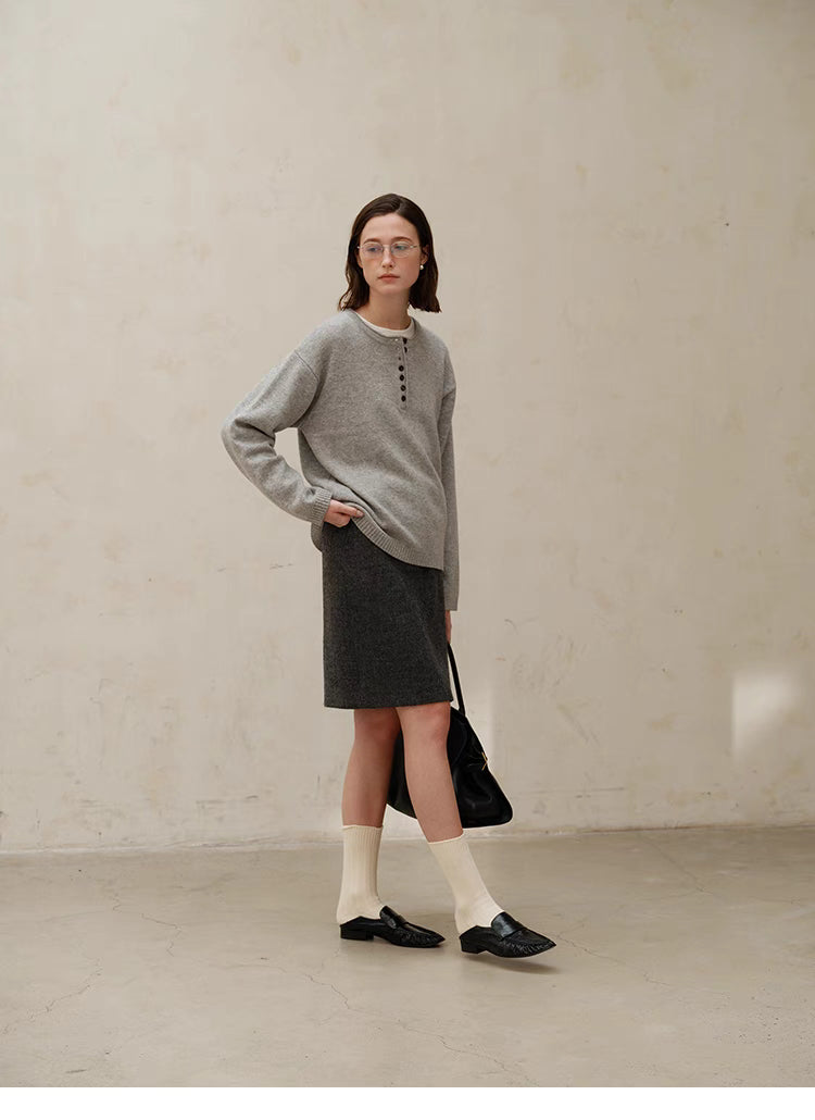Side full body view of model wearing light gray Buttoned Henley Knit Pullover Sweater with relaxed fit