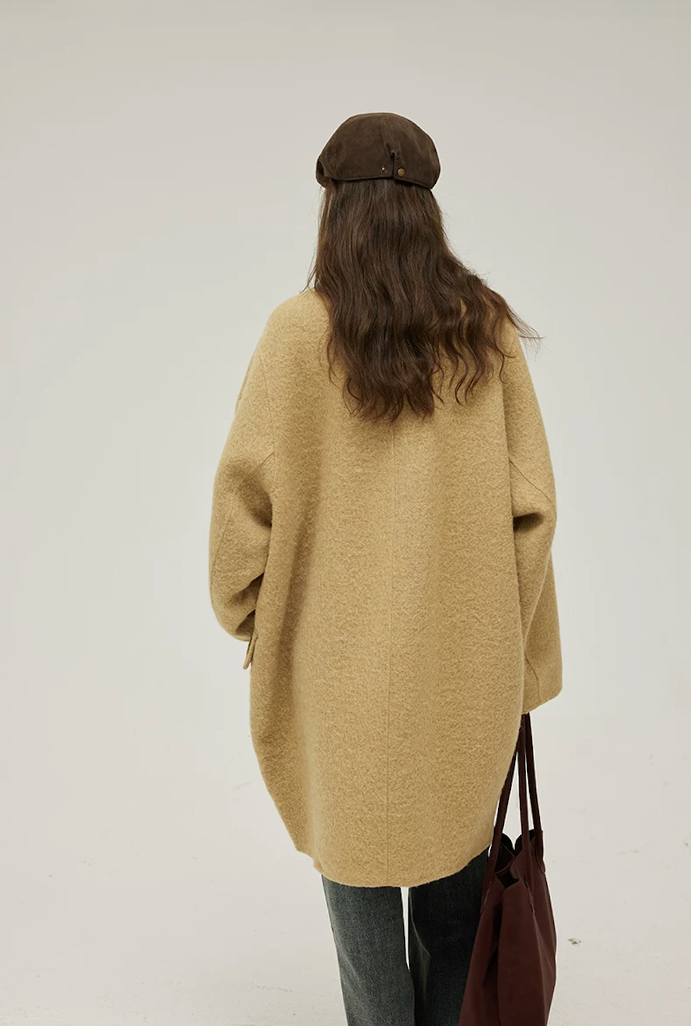 Back view of a Camel cocoon wool coat showing the center back seam and rounded hem