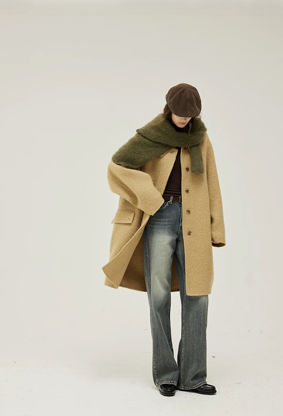 Camel oversized wool coat worn partly open, showing the flap pocket and curved sleeves