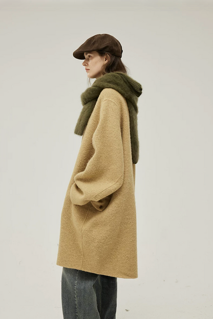 Side profile of a Camel cocoon wool coat showing the rounded body and buttoned flap pocket