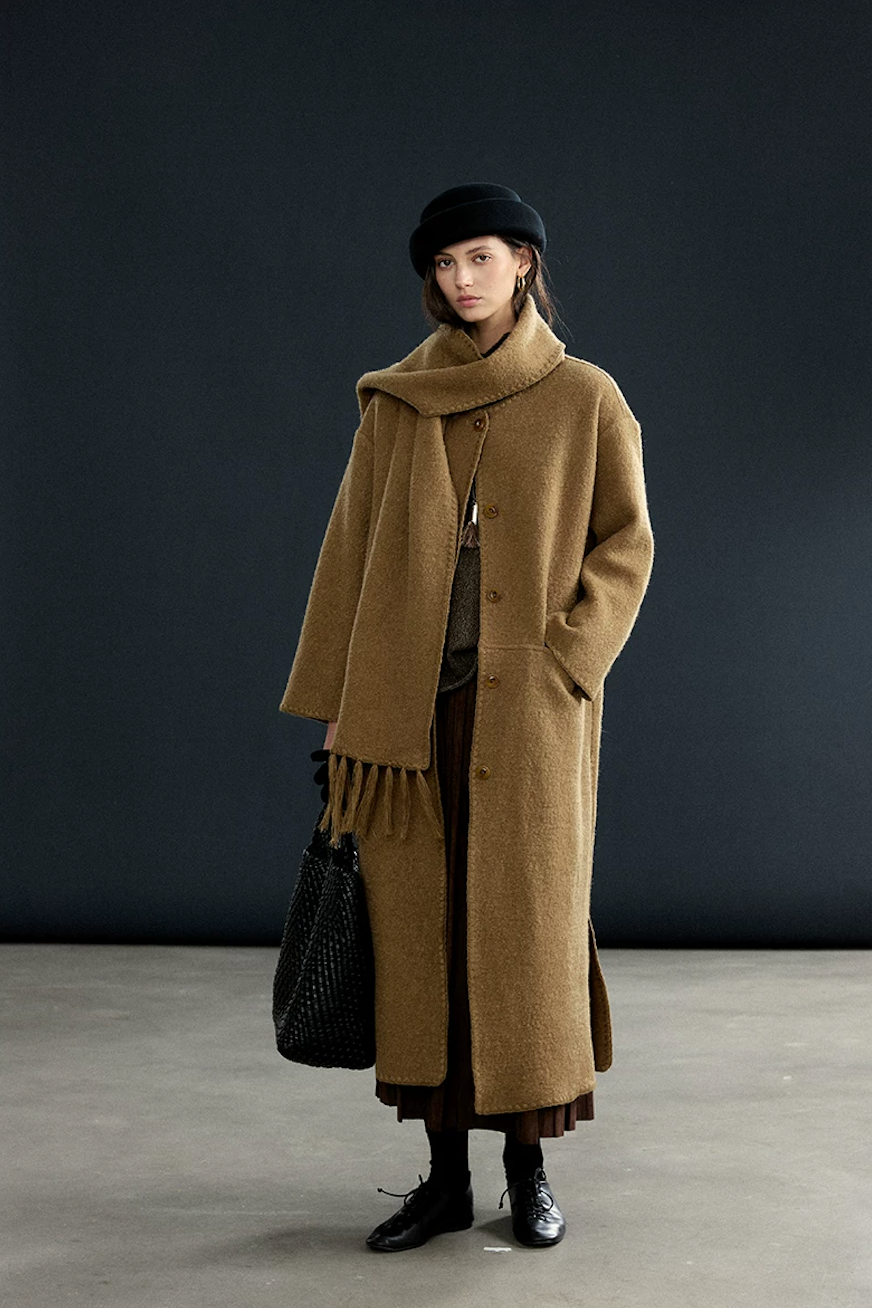 Front view of a Camel mid-calf wool coat buttoned, with the matching fringed scarf draped at the neck