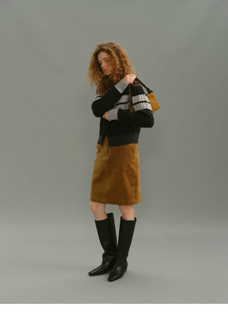 Side profile of a camel corduroy knee-length skirt showing its straight silhouette