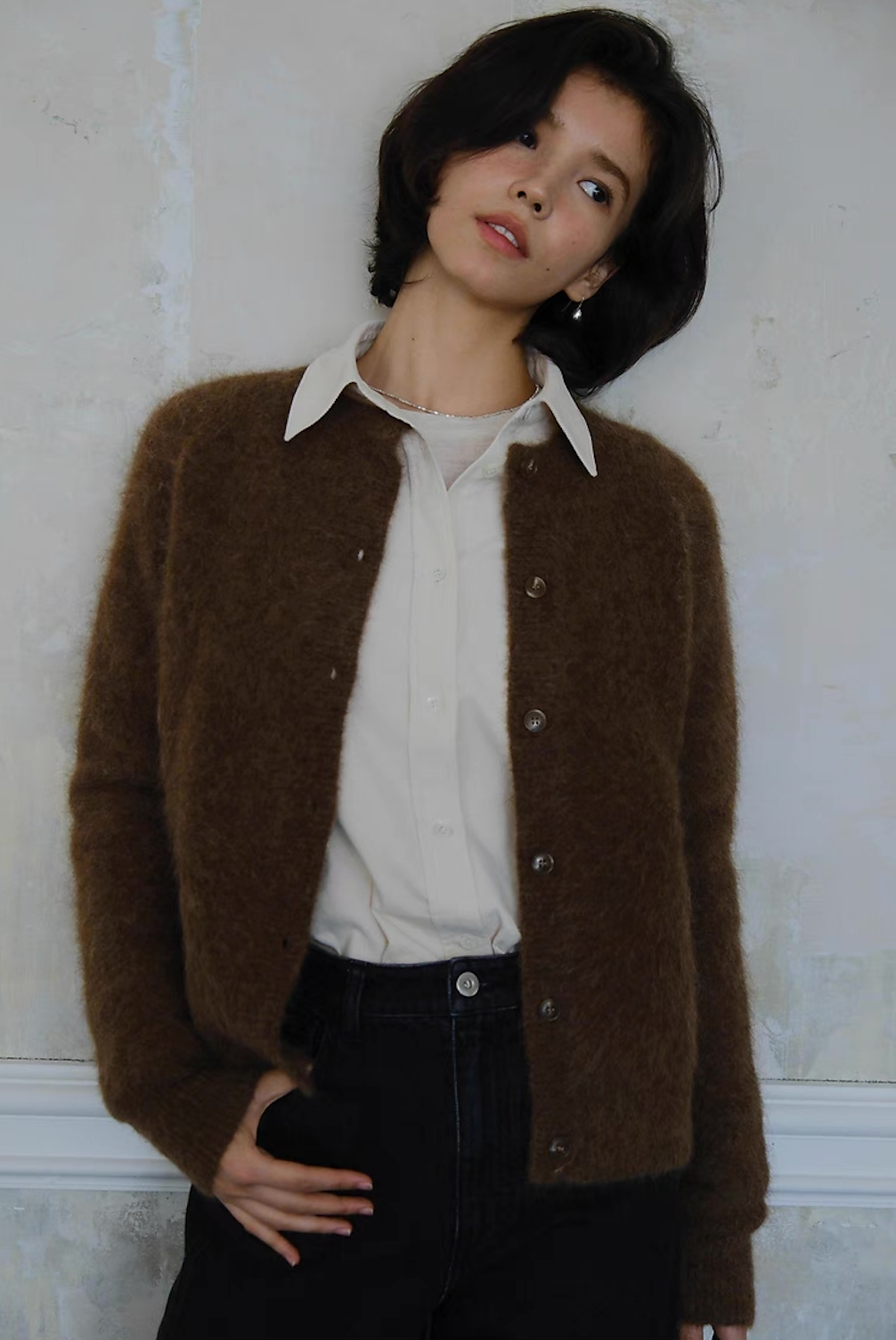 Classic brown knit cardigan paired with white shirt and black jeans