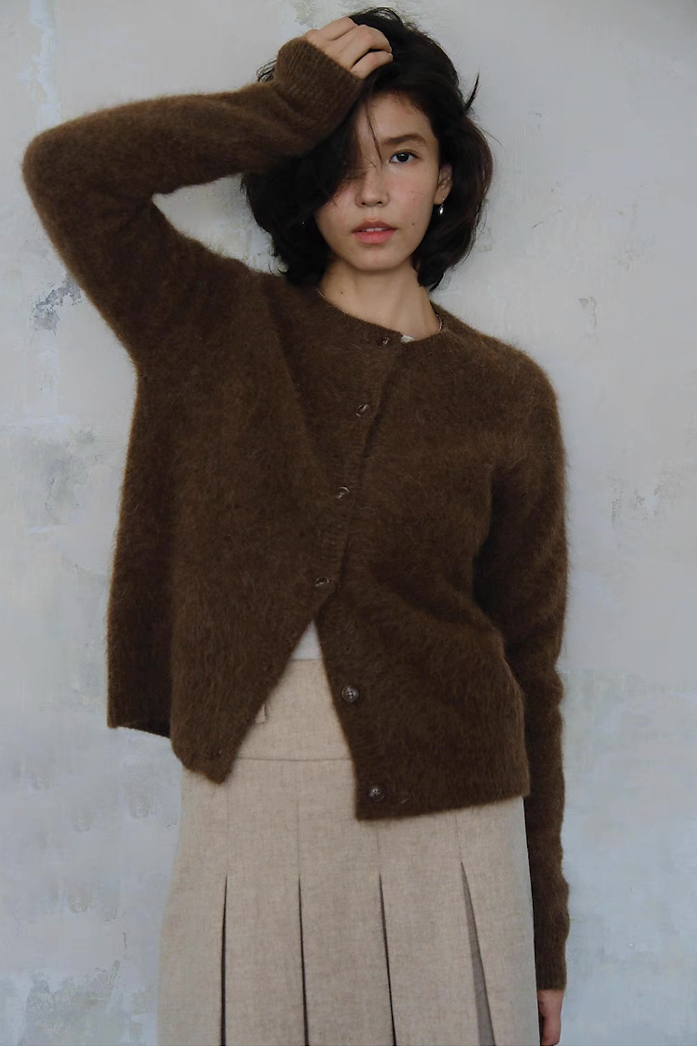 Brown fuzzy knit cardigan styled with beige pleated skirt – chic outfit