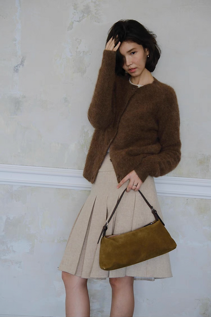 Women’s brown cardigan styled with beige skirt and suede bag