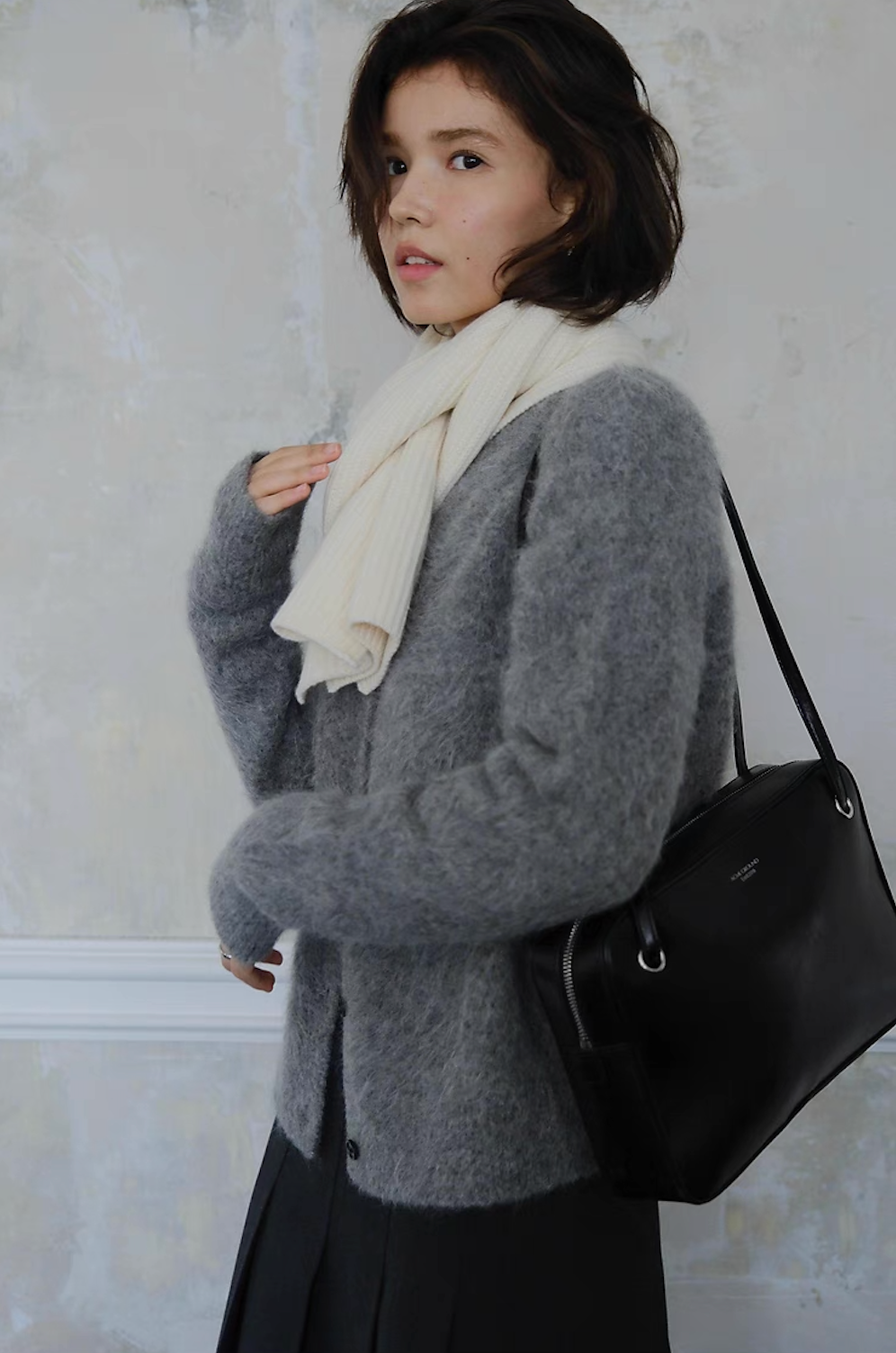 Grey fuzzy cardigan paired with white scarf and black shoulder bag, stylish winter wear