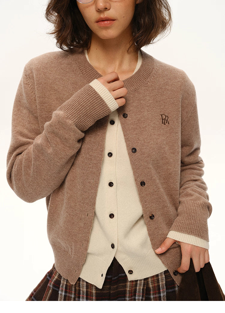 Close-up view of mocha brown wool cardigan showing ribbed cuffs, button placket, and embroidered logo