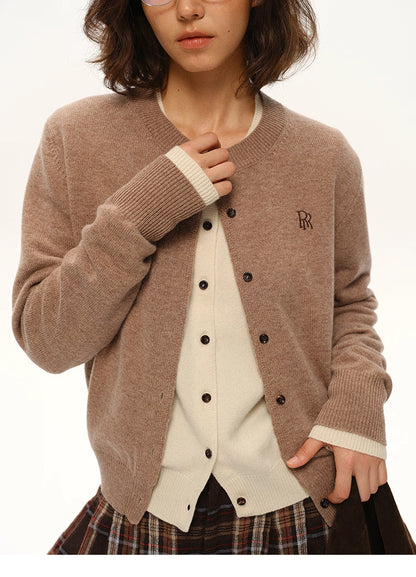 Close-up view of mocha brown wool cardigan showing ribbed cuffs, button placket, and embroidered logo