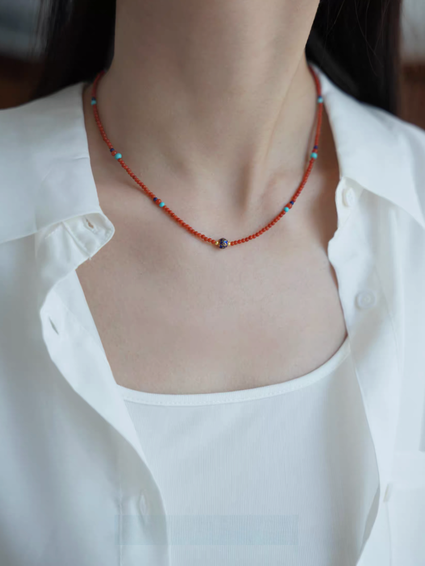 Celestial Harmony beaded necklace worn on neckline featuring red agate beads with turquoise and lapis lazuli accents