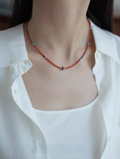 Celestial Harmony beaded necklace worn on neckline featuring red agate beads with turquoise and lapis lazuli accents