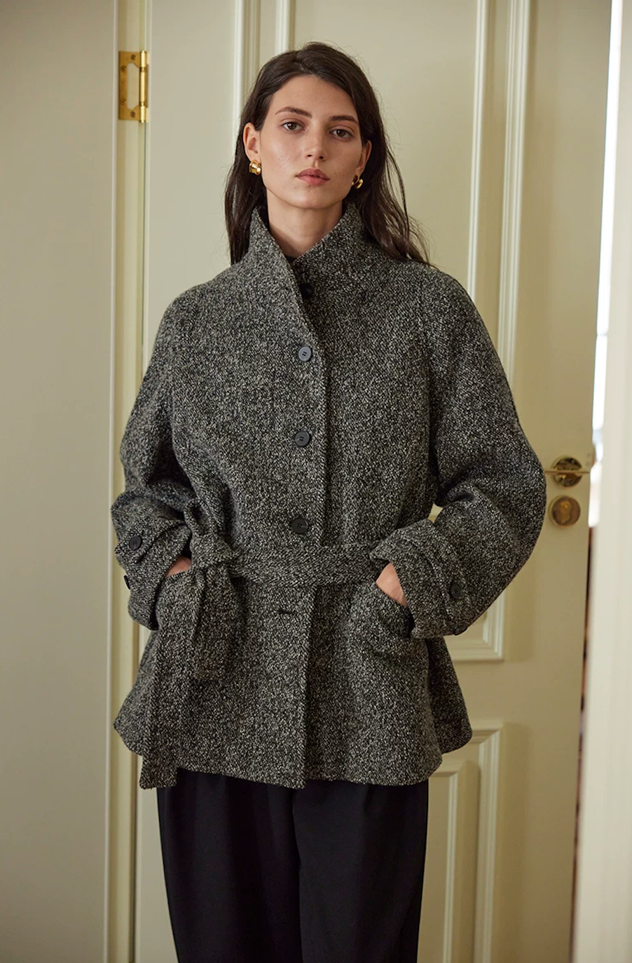 Charcoal salt-and-pepper wool tweed jacket with stand collar, tied self-belt, and buttoned cuff tabs