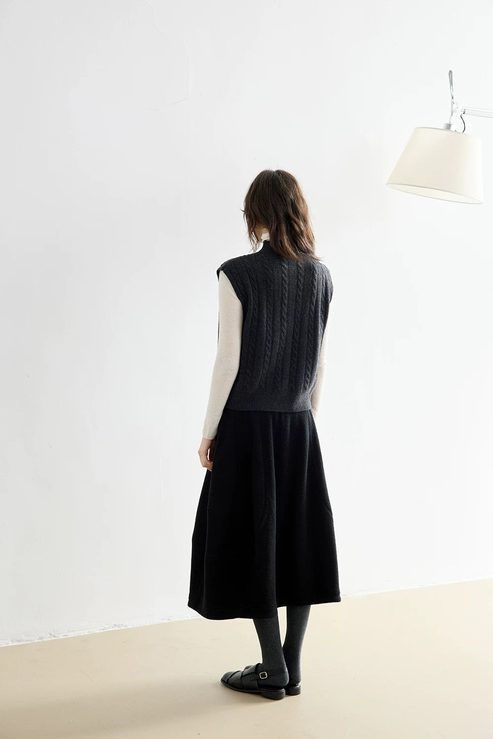 Back view of Charcoal Gray wool vest showing allover cable pattern and ribbed hem