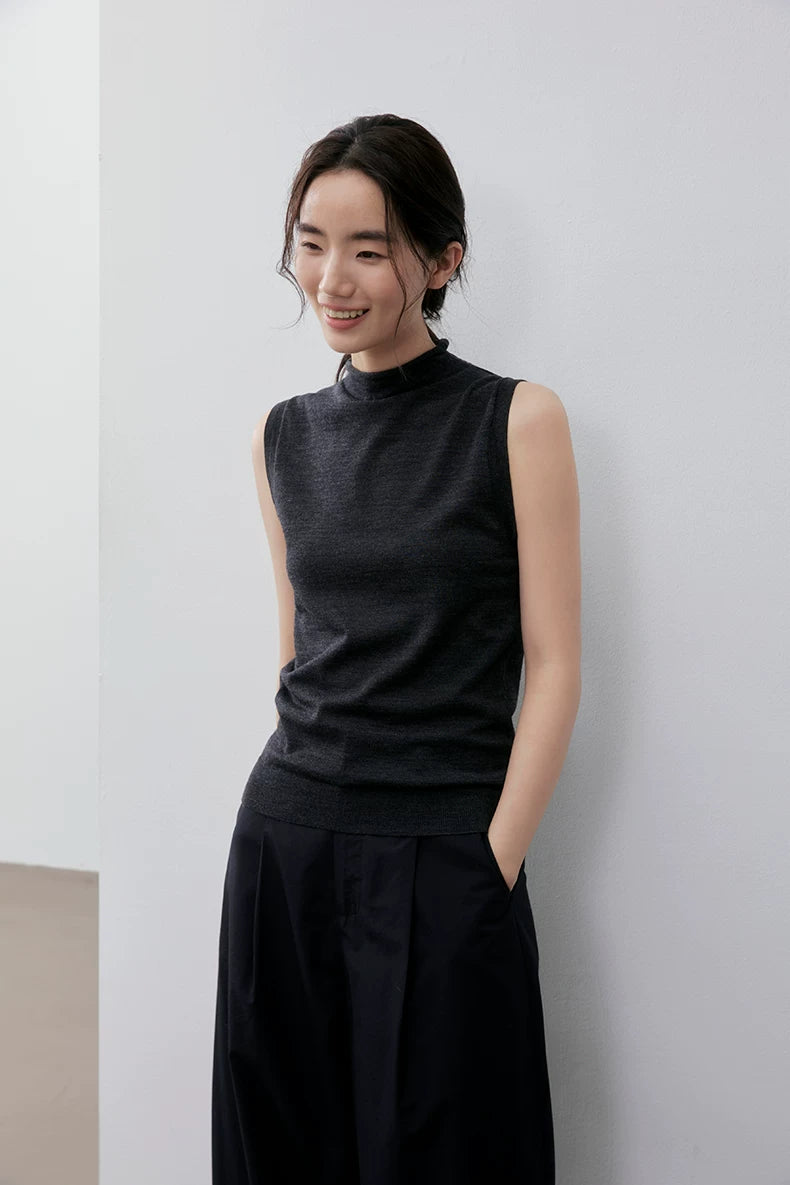 Smiling model in Charcoal Gray mock neck knit top, hands in pockets