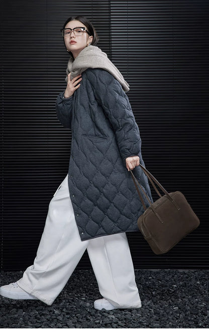 Side view of a Charcoal longline quilted coat in motion, showing the ribbed cuff and hem