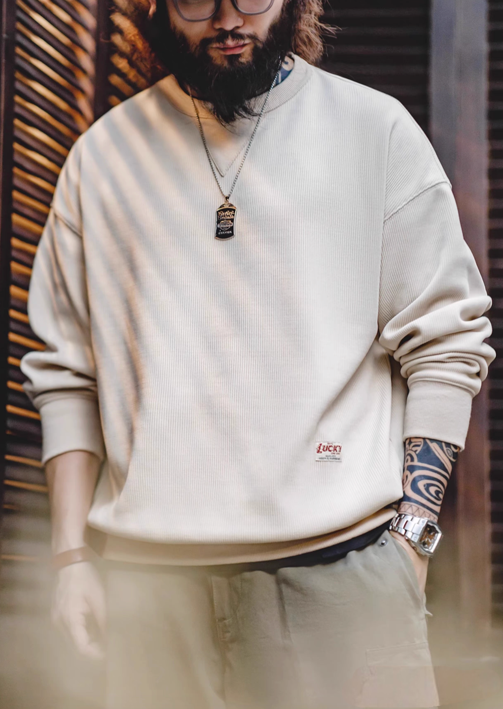Ivory chenille crew sweater with signature triangle neck patch front view showing fabric texture and soft shadow lighting