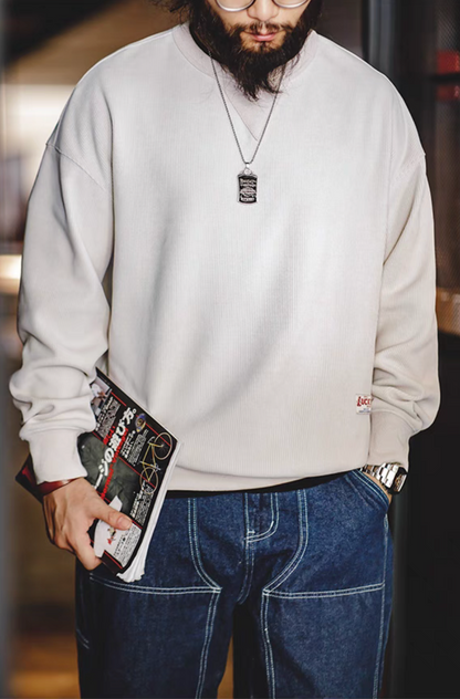 Ivory chenille crew sweater with triangle neck patch worn by model front view casual styling with denim jeans