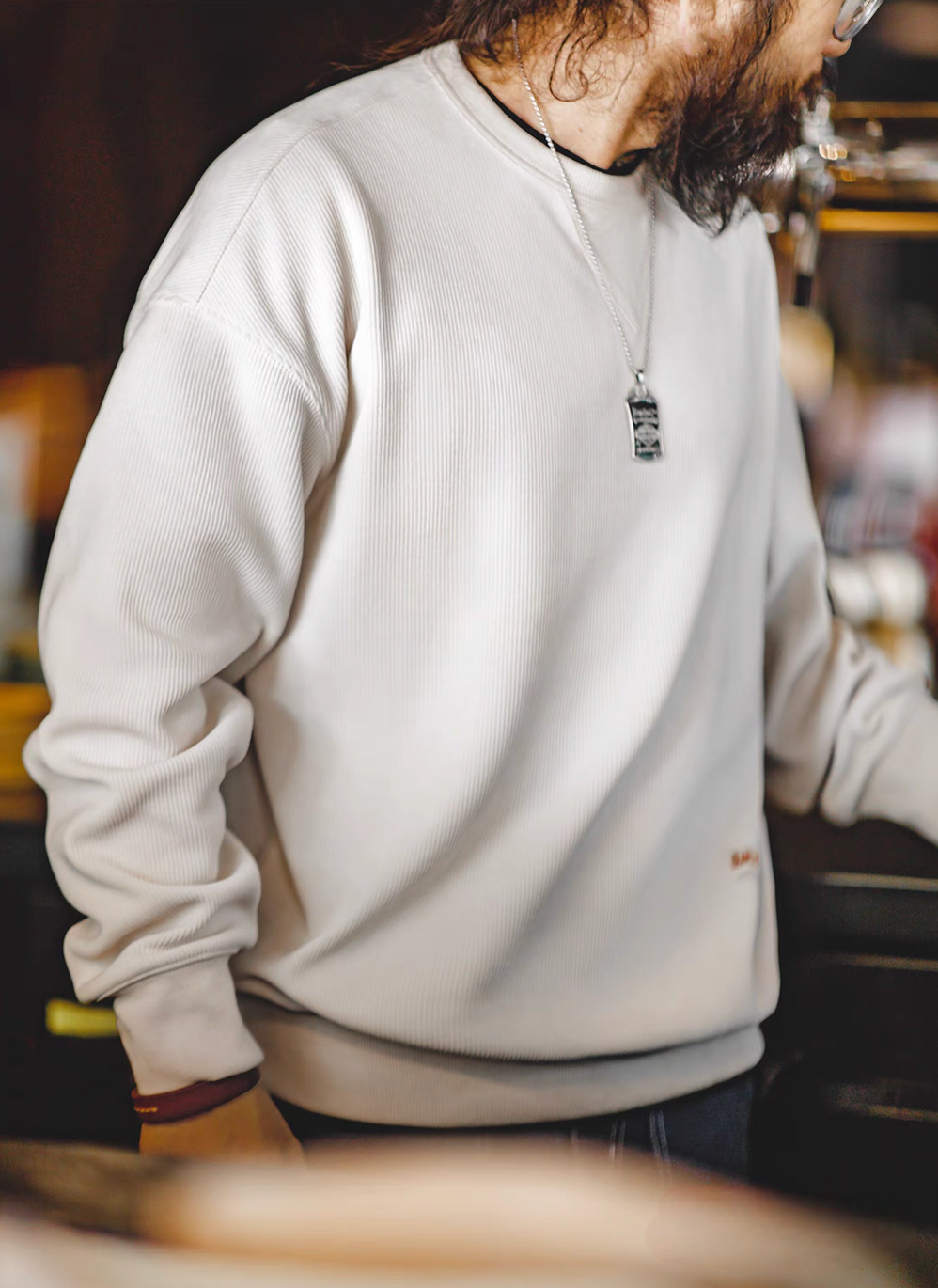 Ivory chenille crew sweater side angle view highlighting relaxed fit long sleeves and ribbed texture detail