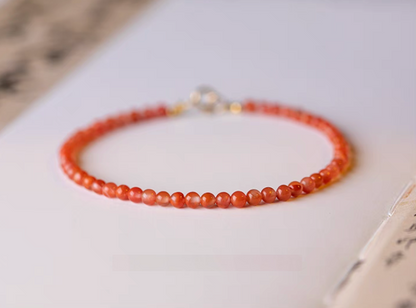 Cherry red agate bracelet full circle view with gold clasp visible on neutral background